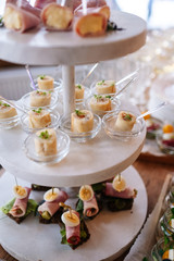 Glasses with seafood snacks and meat on banquet table