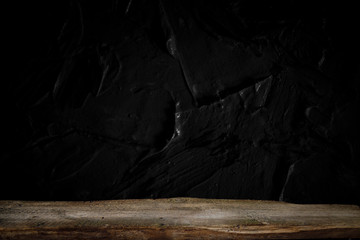 Empty wooden table in front of abstract dark wall background. Can be used to display or edit your products.
