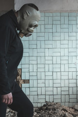 man in a gas mask on a background of a wall and a corridor