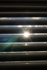 Closed blinds in dark room. Sun shine with rays outdoor