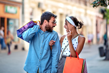 Young happy couple with shopping bags in the city