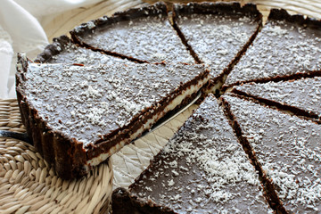 Sliced chocolate tart with coconut cream and crust