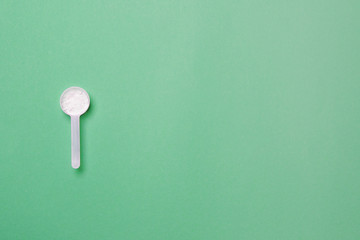 measure spoon on blue colored paper background with copy space