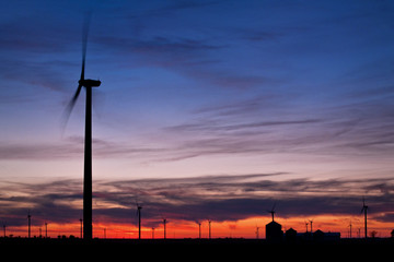 Sunset on a wind turbine farm in the rural Midwest.