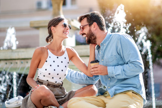 Happy couple sitting together outdoors.