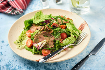 Warm salad with beef, cherry tomatoes and sun-dried tomatoes. Healthy food