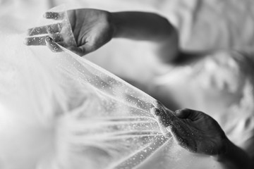 female hands. bride holds a veil over themselves.