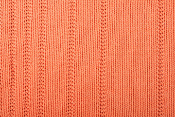 Sweater or scarf fabric texture large knitting. Knitted jersey background with a relief pattern. Braids in knitting . Wool hand- machine, handmade