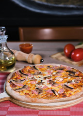 pizza with ham and mushrooms on table