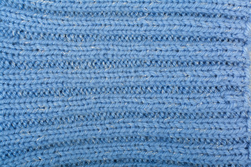 Sweater or scarf fabric texture large knitting. Knitted jersey background with a relief pattern. Braids in knitting . Wool hand- machine, handmade, blue.