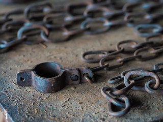 Vintage rusty hand-made iron cast handcuff and a chain