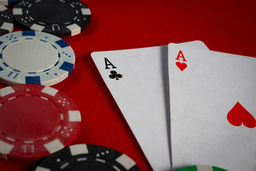 Obraz premium Poker chips and playing cards on a red poker table