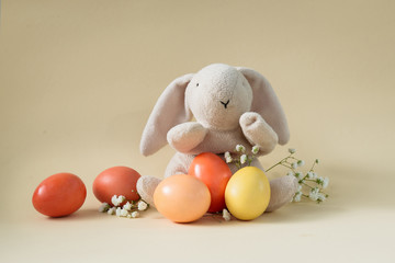 Easter concept with a bunny in nest. Painted easter eggs in egg