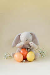 Easter concept with a bunny in nest. Painted easter eggs in egg