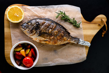 grilled dorada on a wooden board