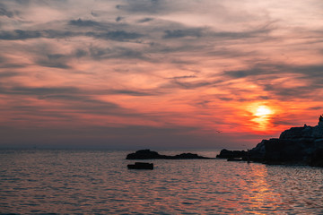 Sunset over the sea, colorful clouds, wide shot. Romantic picture full of colors.