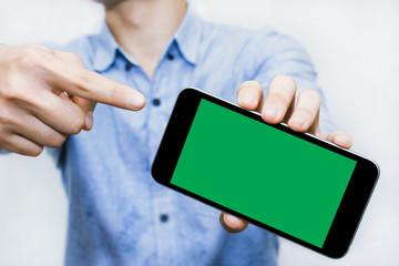 Pointing finger to Green screen smart phone is a template to use for your best content. Blue business shirt