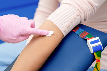 Nurse disinfecting arm skin.