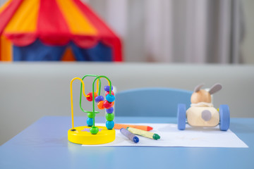 Baby toy and crayons on the table.