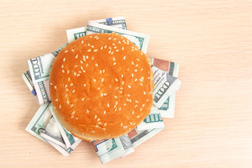 burger with hundred dollar bills instead of filling on a wooden board, top view
