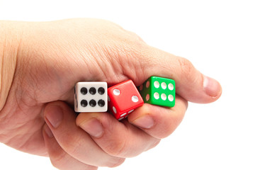 game dice of white red and green color in a hand on a white background isolate, side view