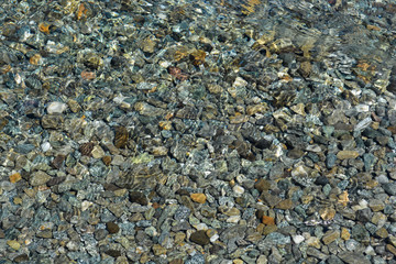 piedras bajo el agua transparente de un arroyo