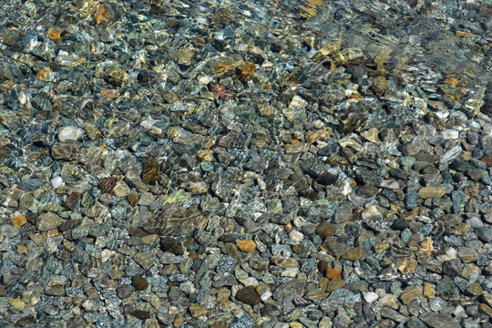piedras bajo el agua transparente de un arroyo