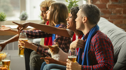 Together. Excited people watching sport match, chsmpionship at home. Multiethnic group of friend, fans cheering for favourite national basketball, tennis, soccer, hockey team. Concept of emotions.