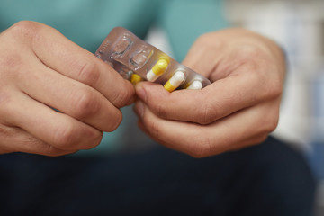 Close-up of man is ill and he is going to drink some medicine from headache