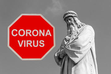 Fototapeta na wymiar Leonardo Da Vinci Statue and the red stop sign of Corona virus, Italy