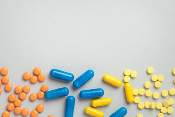 Colorful pills and capsules, medication on gray background with copy space. Health and medication concept. Top view.  