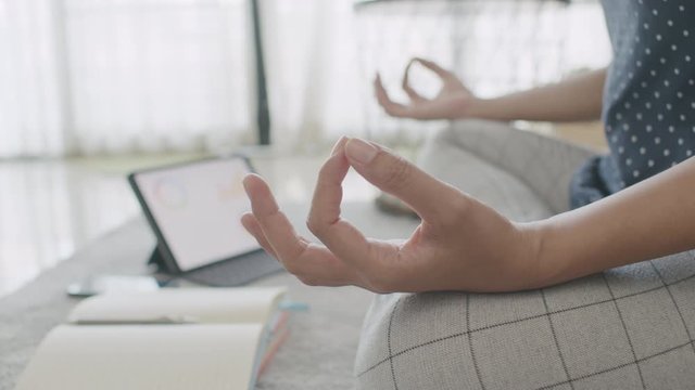 Midsection of woman doing yoga while watching video tutorial