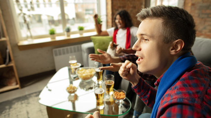 To winning. Excited people watching sport match, chsmpionship at home. Multiethnic group of friend, fans cheering for favourite national basketball, tennis, soccer, hockey team. Concept of emotions.