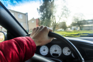 Fototapeta na wymiar driver’s hand holds the steering wheel of the car.