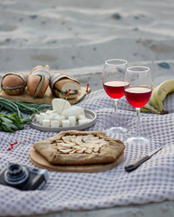 Picnic on the sandy beach with Apple pie and red wine in glasses.