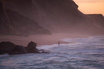 Fishermen in Santa Cruz beach at sunset, in Portugal