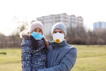 father is wearing a mask to his little daughter to protect the child from pm 2.5 air pollution and covid-19, concept of people lifestyle in crisis of disease outbreak and air problem.