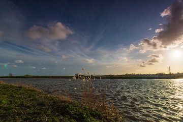 Sunset light view on lake and reed land