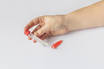 Laboratory tubes in the doctor’s hand with blood serum, with the inscription 