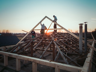 roof repair at sunset; installation of metal tiles; quadcopter shooting; house building