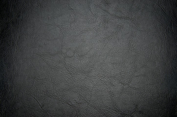 Black textured leather background with ventiing. Vignette on a dark texture background. Vintage.