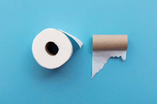 Empty Used Toilet Roll Next To A Full Roll Of Toilet Paper