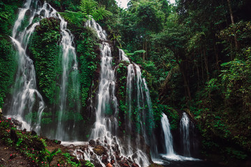 Fototapeta na wymiar Amazing cascade waterfall in a tropical jungle at Bali
