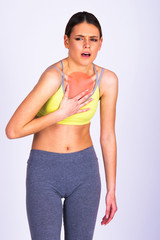Fototapeta na wymiar Young woman feeling chest pain while exercise, isolated on white. Fitness Caucasian girl