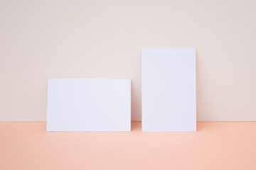 Mockup de tarjetas de visita blancas, horizontal y vertical sobre fondo blanco y melocotón