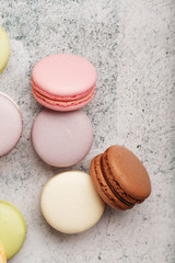 French macaroni cookies of different colors are on the gray table. Still life of confectionery.