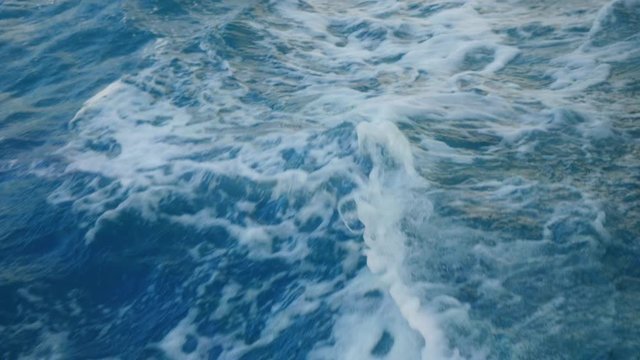Blue sea water with boat trace. Slow motion.