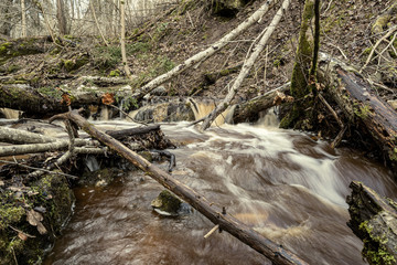 dirty waterfall on a small river in forest