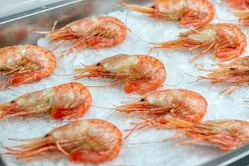 Boiled sea prawns lie on ice. Shrimps are beautifully laid