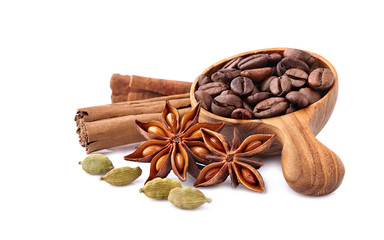 Coffee beans in a wooden spoon with cardamom, cinnamon and anise  on white background. Coffee beans with spices isolated.